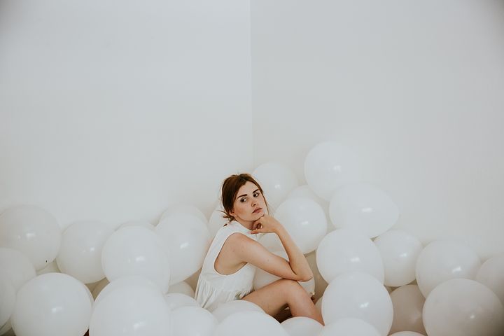 white balloons on the floor and a woman