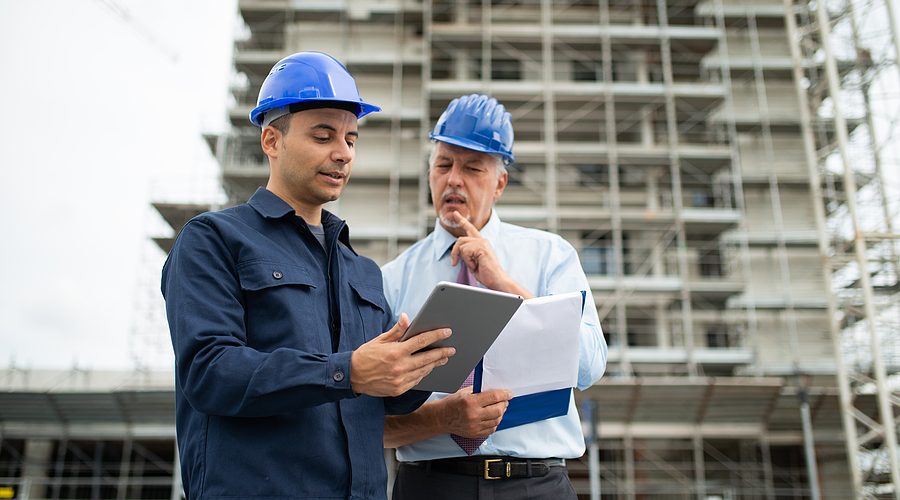 Architect and site manager using a construction ERP software installed in a tablet